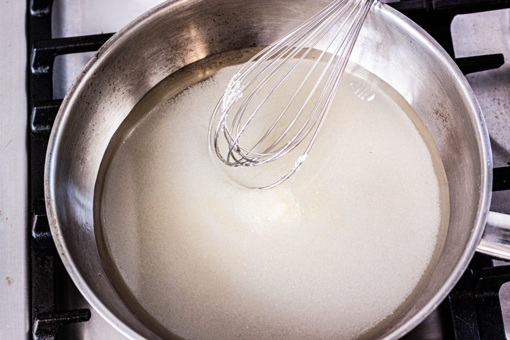 Sugar and water in a saucepan to make caramel.